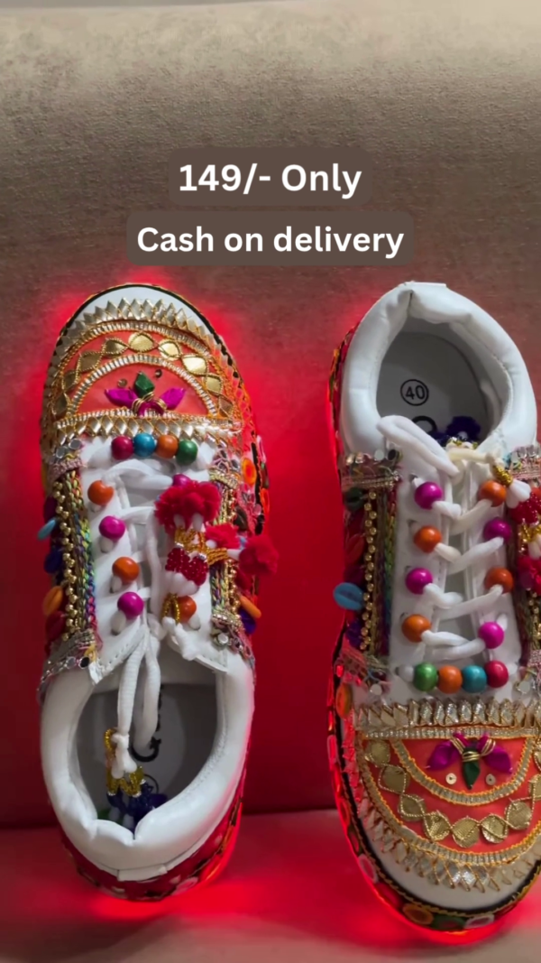 1197-1.png Unisex White Ethnic Mojari Footwear with Multicolor Bead Embroidery – Festive Pair with Red Light Showcase Styling