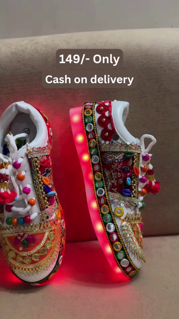 1197-3.png Unisex White Ethnic Mojari Footwear with Multicolor Bead Embroidery – Festive Pair with Red Light Showcase Styling