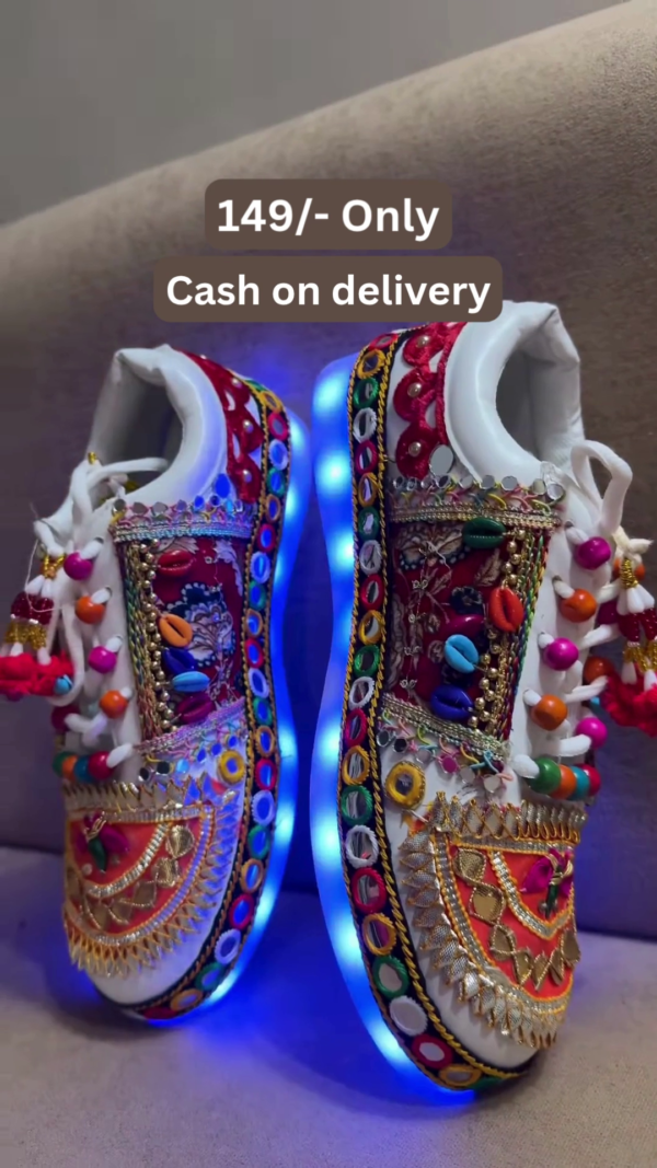 1197-4.png Unisex White Ethnic Mojari Footwear with Multicolor Bead Embroidery – Festive Pair with Red Light Showcase Styling