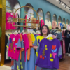 1205-1.png Multicolor Printed Ethnicwear Rack Display – Bold Floral & Abstract Garments in Boutique Interior with Teal-Gold Accents