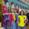 1205-4.png Multicolor Printed Ethnicwear Rack Display – Bold Floral & Abstract Garments in Boutique Interior with Teal-Gold Accents