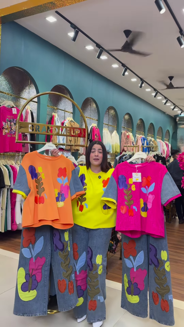 1205-5.png Multicolor Printed Ethnicwear Rack Display – Bold Floral & Abstract Garments in Boutique Interior with Teal-Gold Accents