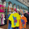 1205-7.png Multicolor Printed Ethnicwear Rack Display – Bold Floral & Abstract Garments in Boutique Interior with Teal-Gold Accents