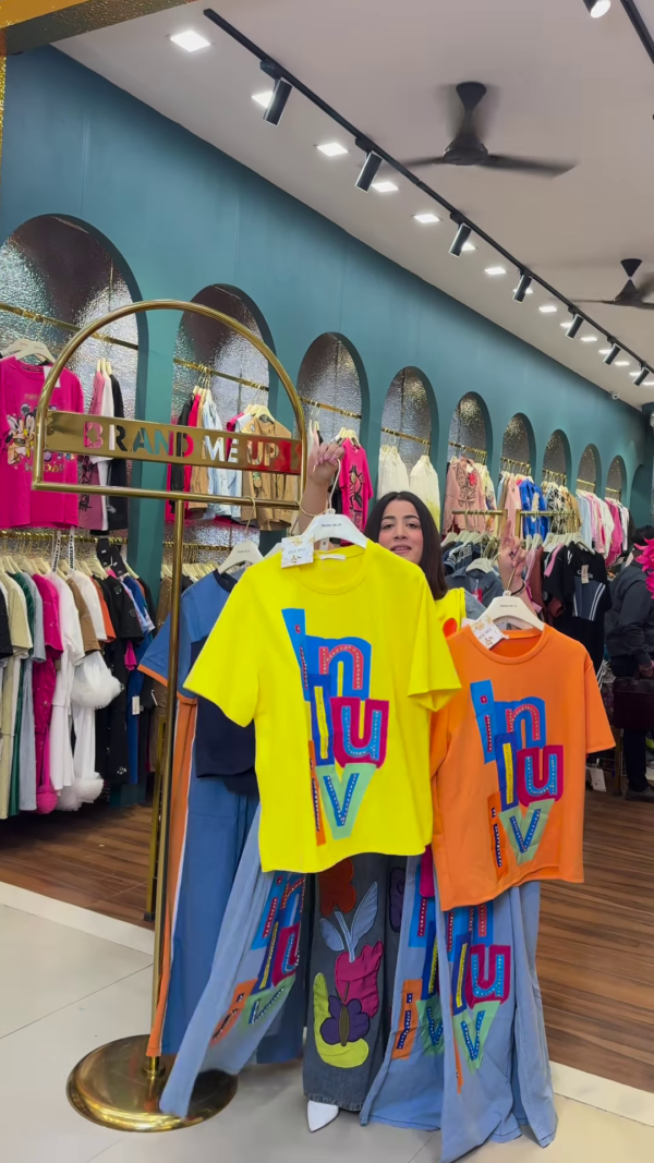 1205-7.png Multicolor Printed Ethnicwear Rack Display – Bold Floral & Abstract Garments in Boutique Interior with Teal-Gold Accents