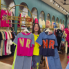 1205-9.png Multicolor Printed Ethnicwear Rack Display – Bold Floral & Abstract Garments in Boutique Interior with Teal-Gold Accents