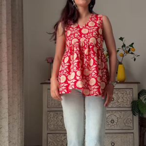 1206-1.png Women’s Sleeveless Red Floral Top with Light Blue Flared Jeans – Indo-Western Casualwear Styled with Vintage Decor Backdrop