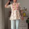 Women’s Sleeveless Red Floral Top with Light Blue Flared Jeans – Indo-Western Casualwear Styled with Vintage Decor Backdrop