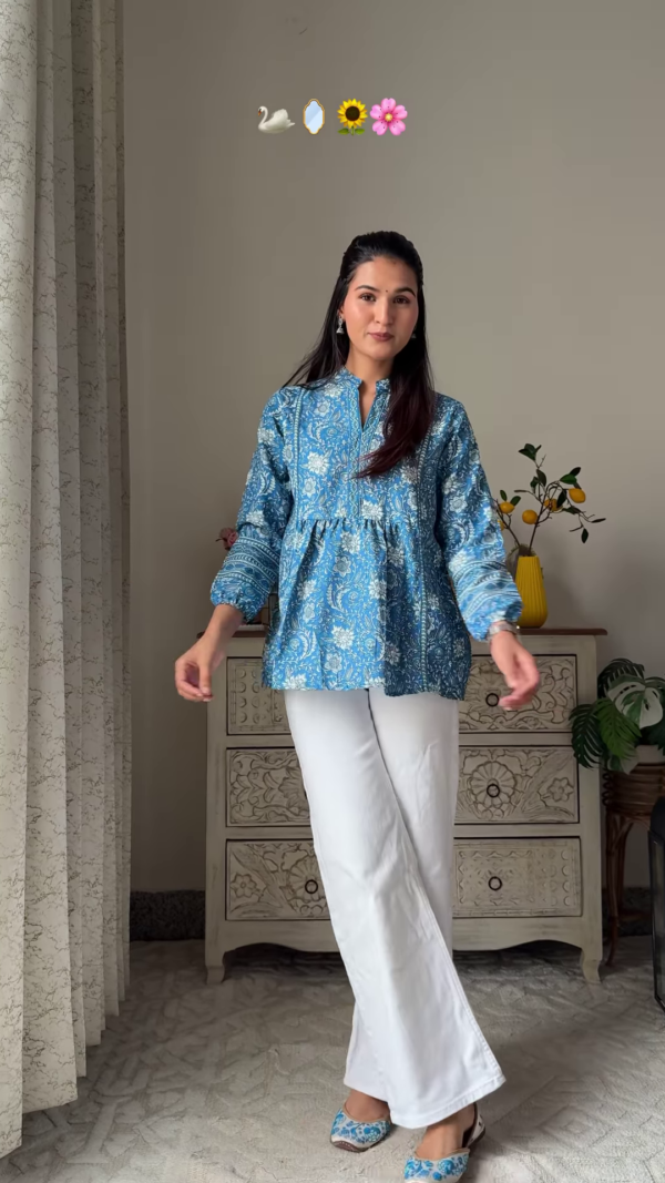 Women’s Sleeveless Red Floral Top with Light Blue Flared Jeans – Indo-Western Casualwear Styled with Vintage Decor Backdrop