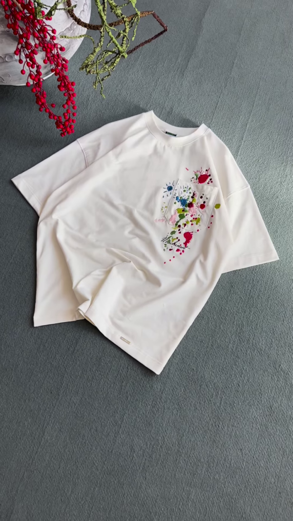 1209-1.png Unisex White & Beige T-Shirts with Colorful Paint Splatter and Pocket Embroidery – Artistic Casualwear for Everyday Styling